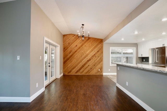 2320 Wekiva Ridge Rd, Apopka, FL 32712 - unfurnished living room with wooden walls, baseboards, dark wood-type flooring, a chandelier, and an accent wall