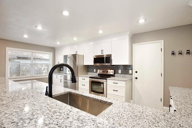 2320 Wekiva Ridge Rd, Apopka, FL 32712 - kitchen with stainless steel appliances, a sink, decorative backsplash, white cabinets, and recessed lighting