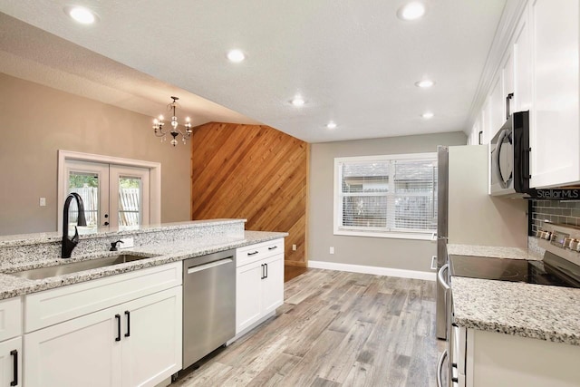 2320 Wekiva Ridge Rd, Apopka, FL 32712 - kitchen with stainless steel appliances, a sink, wood walls, recessed lighting, and white cabinets