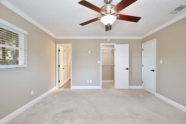 2320 Wekiva Ridge Rd, Apopka, FL 32712 - unfurnished bedroom featuring crown molding, light carpet, baseboards, a walk in closet, and a textured ceiling