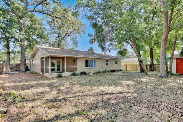 2320 Wekiva Ridge Rd, Apopka, FL 32712 - rear view of house with a sunroom, a fenced backyard, and a chimney