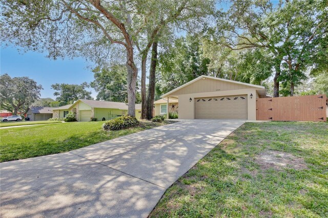 2320 Wekiva Ridge Rd, Apopka, FL 32712 - ranch-style house with driveway, a garage, a front lawn, and a gate