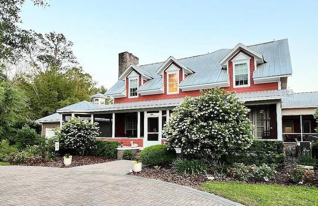 11317 NW 199th Ave, Alachua, FL 32615 - cape cod-style house with a chimney, a sunroom, and metal roof