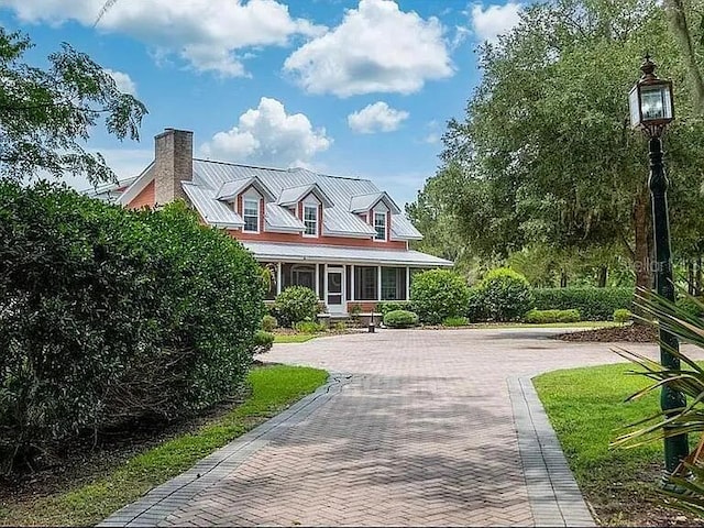 11317 NW 199th Ave, Alachua, FL 32615 - cape cod house with a chimney, decorative driveway, and metal roof