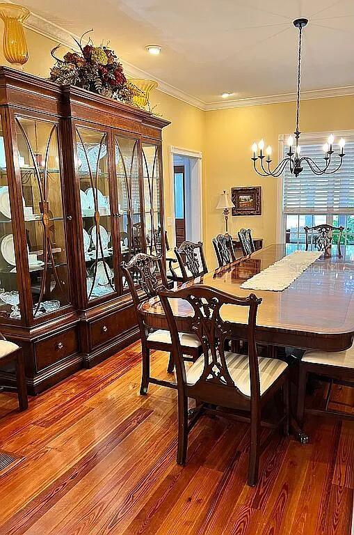 11317 NW 199th Ave, Alachua, FL 32615 - dining space with a chandelier, wood-type flooring, and ornamental molding