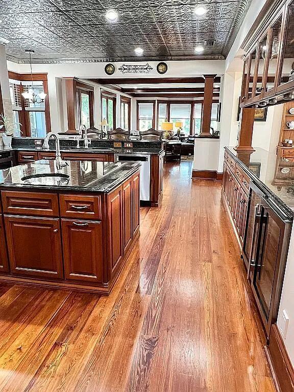 11317 NW 199th Ave, Alachua, FL 32615 - kitchen featuring an ornate ceiling, an island with sink, stainless steel dishwasher, a sink, and hardwood / wood-style flooring