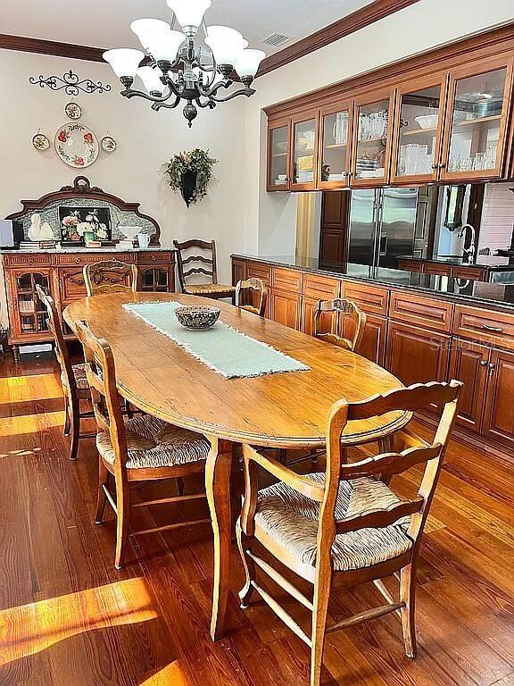 11317 NW 199th Ave, Alachua, FL 32615 - dining area featuring ornamental molding, a chandelier, and dark wood-style flooring