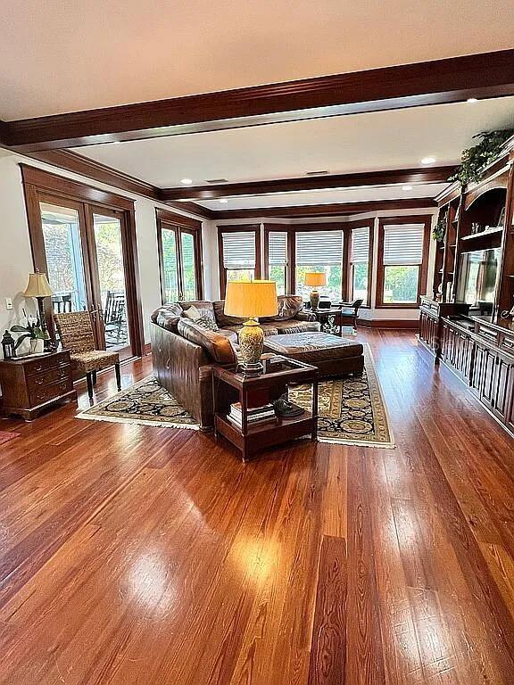 11317 NW 199th Ave, Alachua, FL 32615 - living area with beamed ceiling, wood finished floors, healthy amount of natural light, and crown molding