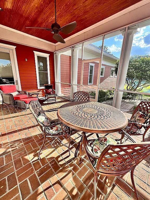 11317 NW 199th Ave, Alachua, FL 32615 - sunroom featuring brick floors, ceiling fan, ornamental molding, wooden ceiling, and outdoor dining space