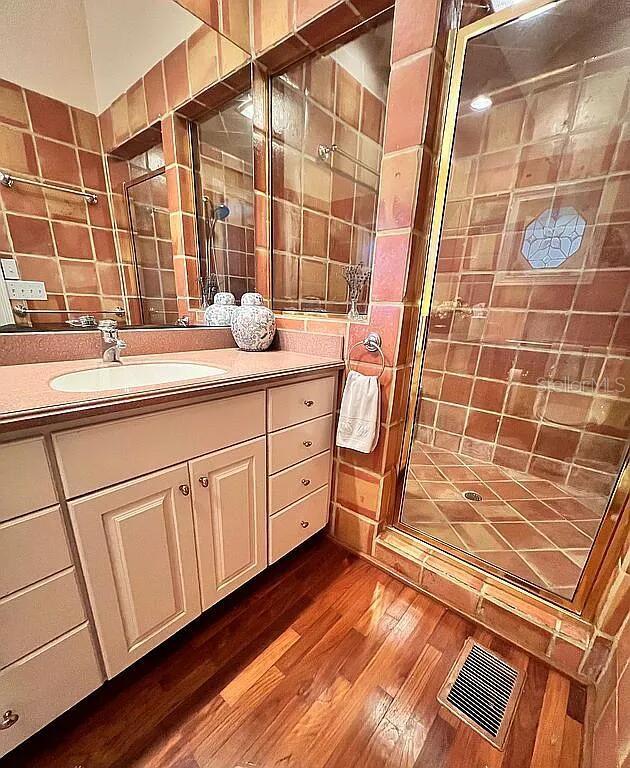 11317 NW 199th Ave, Alachua, FL 32615 - full bathroom featuring wood finished floors, a shower stall, and vanity