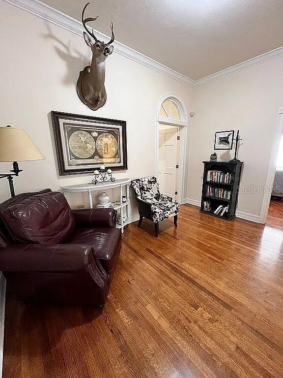 11317 NW 199th Ave, Alachua, FL 32615 - sitting room featuring wood finished floors, crown molding, and baseboards