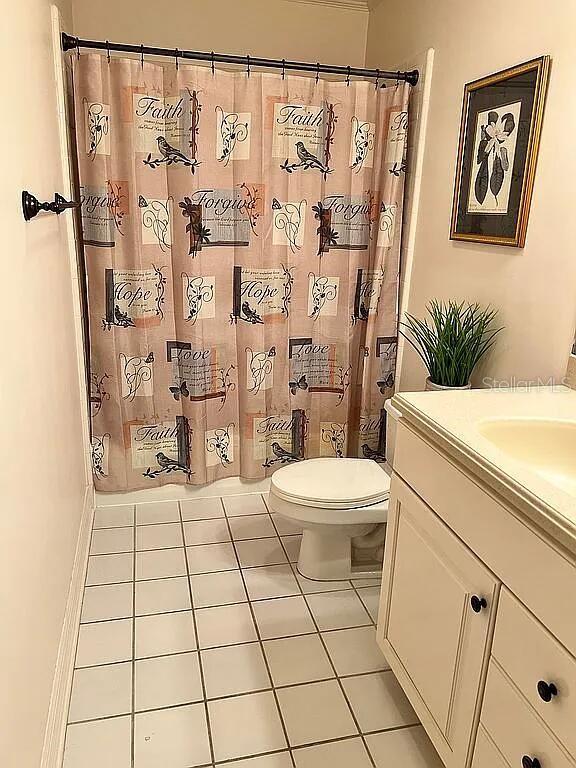 11317 NW 199th Ave, Alachua, FL 32615 - bathroom with tile patterned floors, toilet, a shower with shower curtain, and vanity