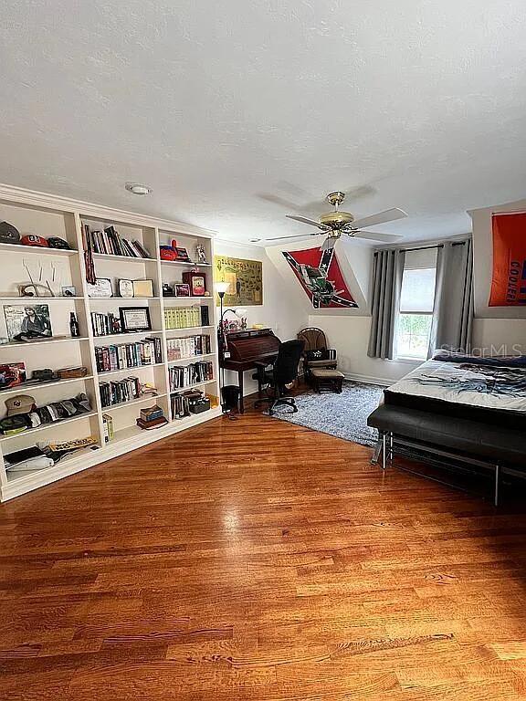 11317 NW 199th Ave, Alachua, FL 32615 - bedroom with wood finished floors, ceiling fan, and a textured ceiling