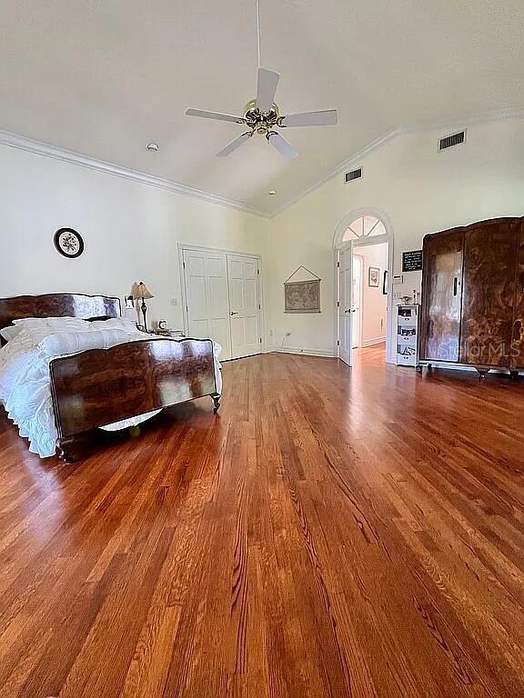11317 NW 199th Ave, Alachua, FL 32615 - bedroom with wood finished floors, lofted ceiling, crown molding, and ceiling fan
