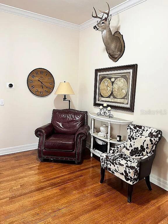 11317 NW 199th Ave, Alachua, FL 32615 - sitting room with wood finished floors, baseboards, and crown molding