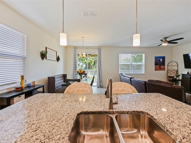 4553 Baler Trails Dr, Saint Cloud, FL 34772 - kitchen with ceiling fan, a sink, light stone countertops, hanging light fixtures, and open floor plan