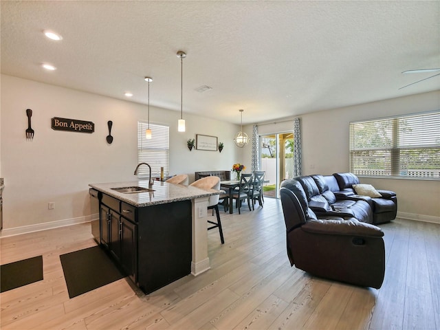 4553 Baler Trails Dr, Saint Cloud, FL 34772 - kitchen with a sink, a breakfast bar area, dishwasher, open floor plan, and an island with sink