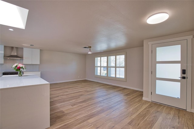 1933 Oregon Trl, Englewood, FL 34224 - unfurnished living room featuring light wood-type flooring, baseboards, a skylight, and ceiling fan
