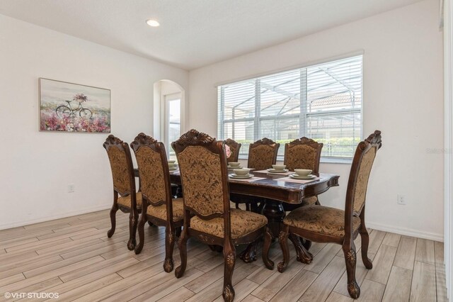 7017 Oakwood St, Davenport, FL 33837 - dining area with light wood-style flooring, arched walkways, recessed lighting, and baseboards
