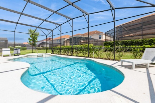7017 Oakwood St, Davenport, FL 33837 - view of swimming pool featuring a patio area, a pool with connected hot tub, glass enclosure, and a residential view