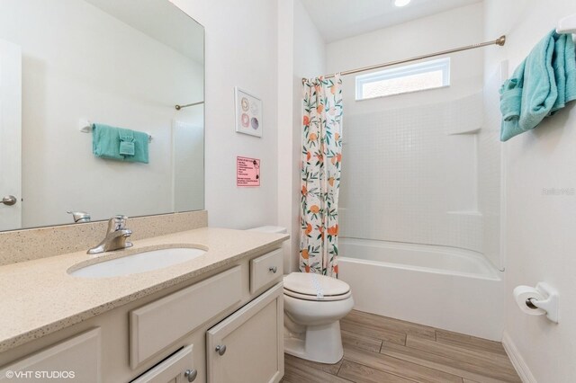 7017 Oakwood St, Davenport, FL 33837 - full bathroom featuring vanity, shower / tub combo with curtain, toilet, and wood finished floors