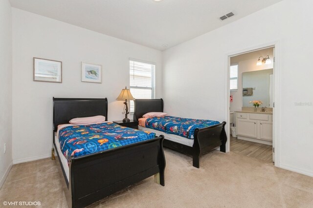 7017 Oakwood St, Davenport, FL 33837 - bedroom featuring light carpet, multiple windows, and ensuite bath