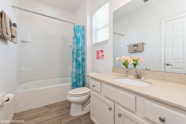 7017 Oakwood St, Davenport, FL 33837 - bathroom featuring vanity, shower / bath combo, wood finished floors, and toilet