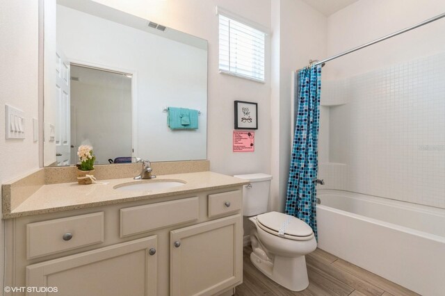7017 Oakwood St, Davenport, FL 33837 - bathroom with toilet, shower / bath combination with curtain, vanity, and wood finished floors