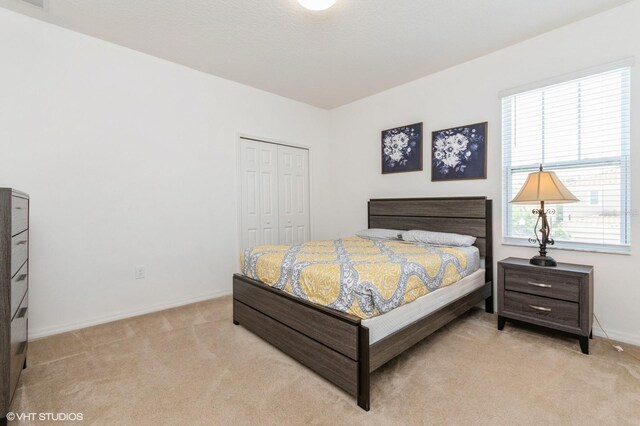 7017 Oakwood St, Davenport, FL 33837 - bedroom featuring light colored carpet, a closet, and baseboards