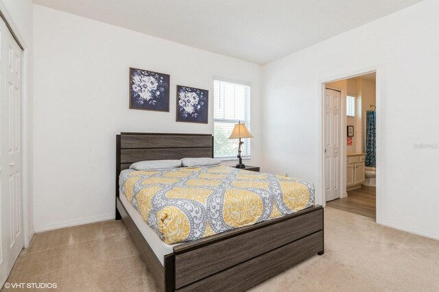 7017 Oakwood St, Davenport, FL 33837 - bedroom with light carpet, baseboards, ensuite bath, and a closet