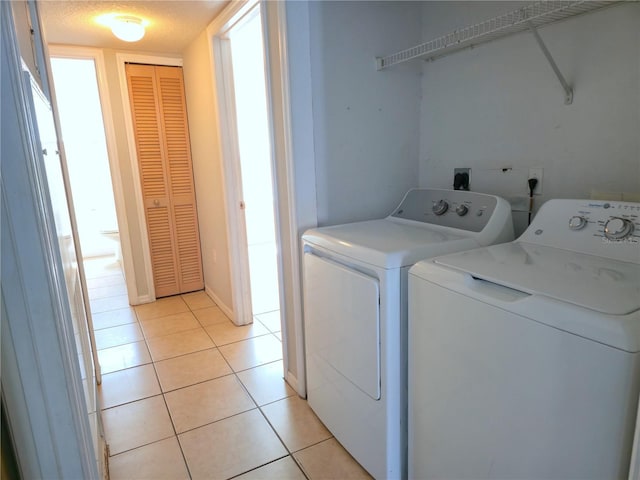 3157 Britannia Blvd Unit B, Kissimmee, FL 34747 - laundry room featuring washing machine and dryer, light tile patterned flooring, and baseboards