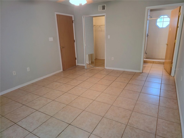 3157 Britannia Blvd Unit B, Kissimmee, FL 34747 - unfurnished bedroom with light tile patterned floors, a spacious closet, a closet, and baseboards