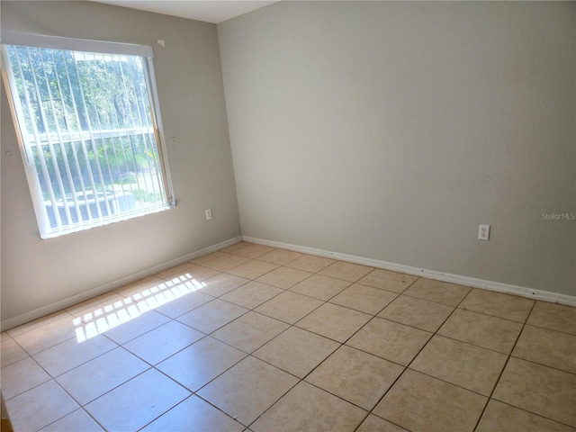 3157 Britannia Blvd Unit B, Kissimmee, FL 34747 - spare room featuring healthy amount of natural light, light tile patterned floors, and baseboards