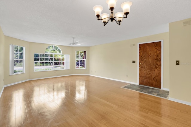 2020 Royal Bay Blvd Unit 91, Kissimmee, FL 34746 - unfurnished living room with a chandelier, healthy amount of natural light, light wood-type flooring, and a textured ceiling