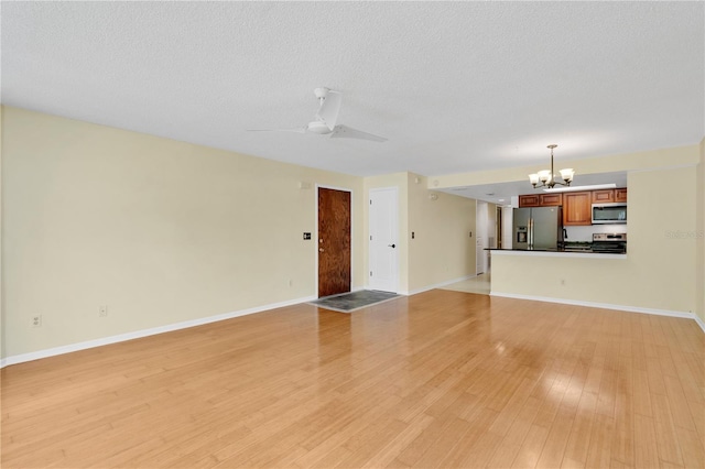 2020 Royal Bay Blvd Unit 91, Kissimmee, FL 34746 - unfurnished living room with a chandelier, light wood-style floors, ceiling fan, baseboards, and a textured ceiling