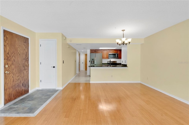 2020 Royal Bay Blvd Unit 91, Kissimmee, FL 34746 - unfurnished living room featuring a chandelier, light wood-style floors, and baseboards