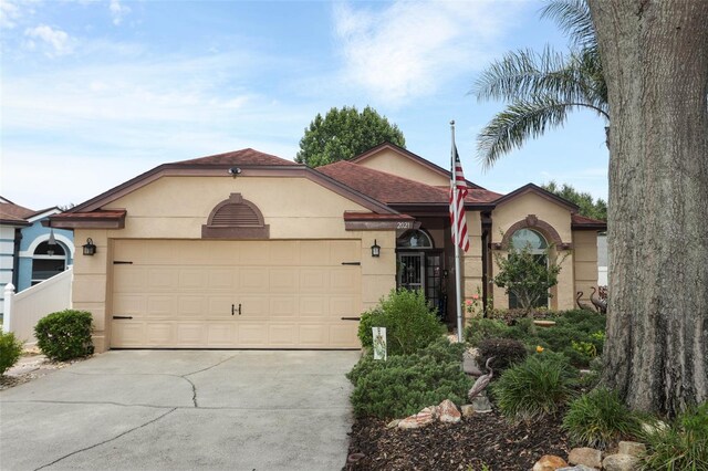 2021 Wildfire Ct, Apopka, FL 32703 - view of front facade featuring stucco siding, a garage, concrete driveway, and roof with shingles