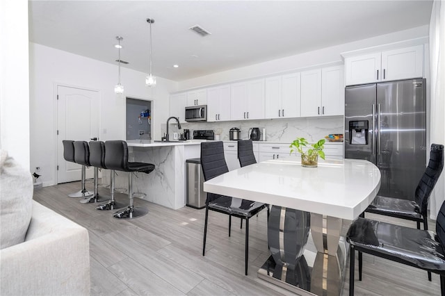 17614 Woodcrest Way, Clermont, FL 34714 - kitchen with appliances with stainless steel finishes, a center island with sink, a kitchen breakfast bar, a sink, and light countertops