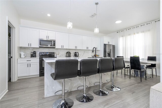 17614 Woodcrest Way, Clermont, FL 34714 - kitchen with stainless steel appliances, an island with sink, a kitchen breakfast bar, decorative backsplash, and recessed lighting