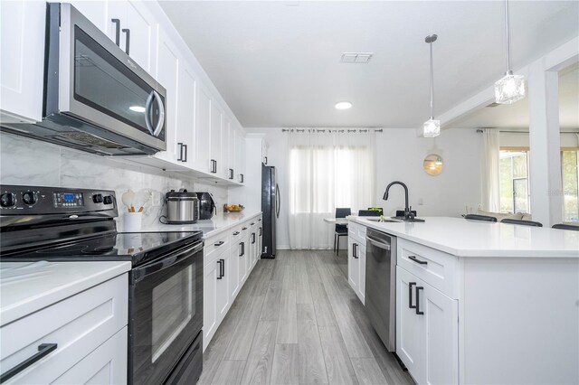 17614 Woodcrest Way, Clermont, FL 34714 - kitchen featuring stainless steel appliances, a sink, plenty of natural light, white cabinetry, and recessed lighting