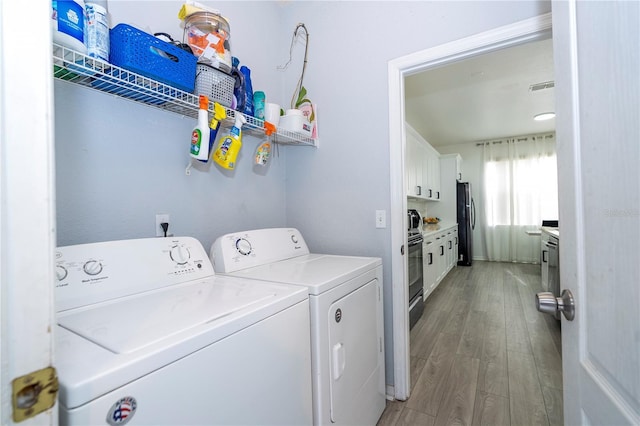 17614 Woodcrest Way, Clermont, FL 34714 - laundry area with washer and dryer and light wood-style flooring