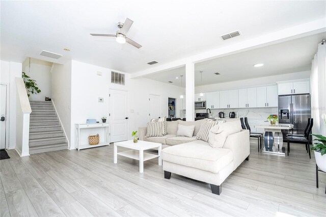 17614 Woodcrest Way, Clermont, FL 34714 - living area featuring a ceiling fan, stairway, and light wood finished floors