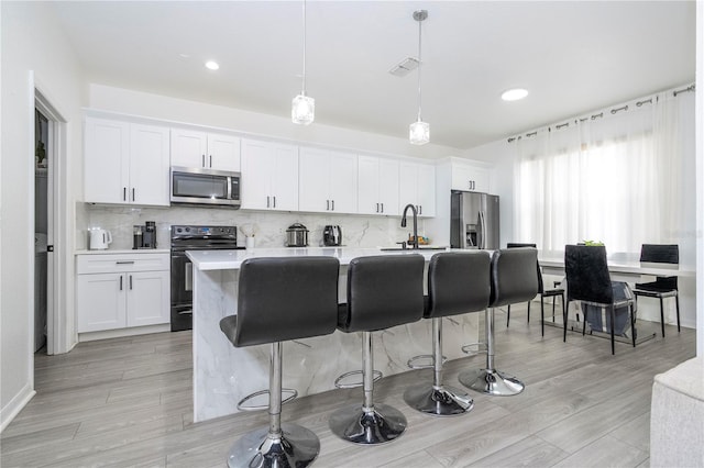 17614 Woodcrest Way, Clermont, FL 34714 - kitchen with stainless steel appliances, an island with sink, a kitchen breakfast bar, decorative backsplash, and recessed lighting