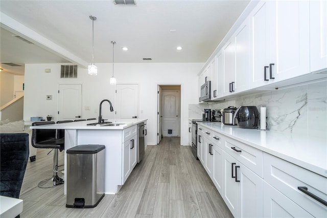 17614 Woodcrest Way, Clermont, FL 34714 - kitchen featuring a sink, appliances with stainless steel finishes, tasteful backsplash, a breakfast bar, and a center island with sink