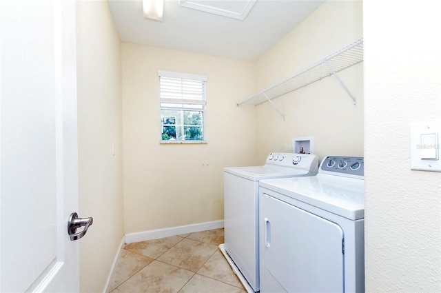 1748 Thetford Cir, Orlando, FL 32824 - laundry room with washing machine and clothes dryer, light tile patterned floors, and baseboards