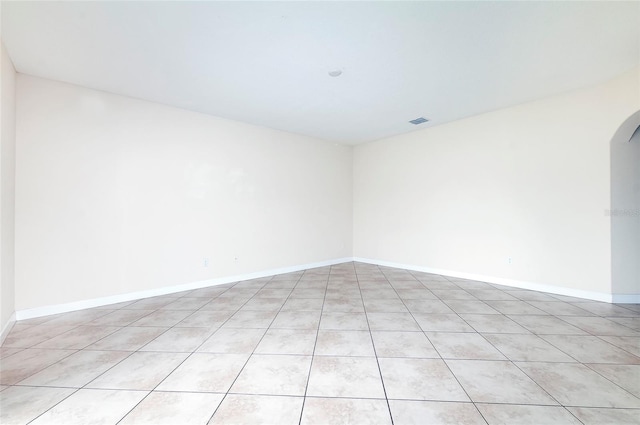 1748 Thetford Cir, Orlando, FL 32824 - unfurnished room with arched walkways, light tile patterned floors, and baseboards