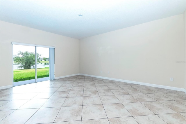 1748 Thetford Cir, Orlando, FL 32824 - unfurnished room with baseboards, light tile patterned floors, and a water view