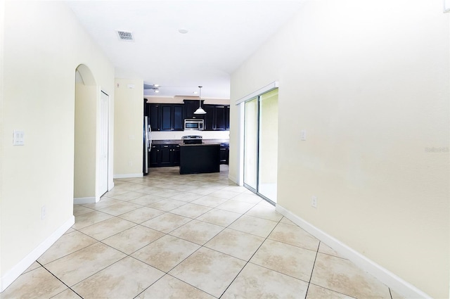 1748 Thetford Cir, Orlando, FL 32824 - unfurnished living room featuring light tile patterned floors, arched walkways, and baseboards