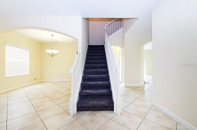 1748 Thetford Cir, Orlando, FL 32824 - stairway featuring tile patterned flooring, arched walkways, and a chandelier