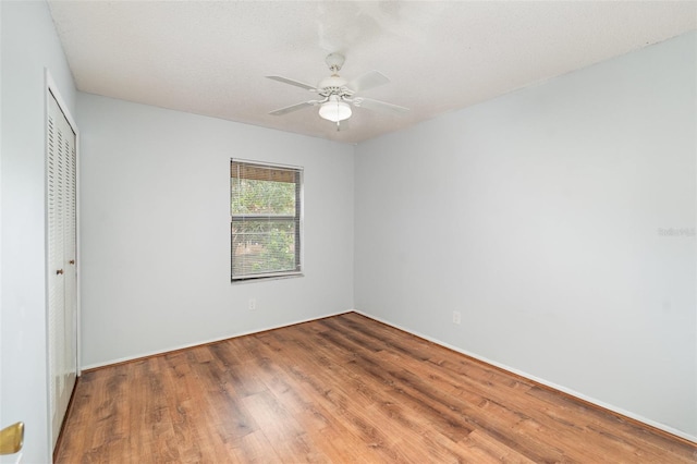 450 S Buena Vista Ave, Orlando, FL 32835 - unfurnished bedroom with a closet, wood finished floors, a ceiling fan, and baseboards